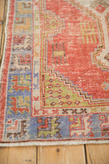 Distressed Turkish Oushak rug runner with brick red field, stepped lime green, and faded blue borders.