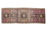 Vintage distressed Oushak runner features repeating guls in violet, beige, and brown, 3'2