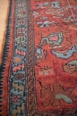 Vintage Lilihan rug's red field, blue serrated leaf border, and visible knot wear.