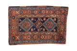 Antique Heriz rug with stepped medallions and scattered birds on an indigo field with a terracotta border.
