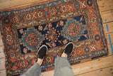 Overhead view of an antique Heriz rug showing scale with its geometric medallions and terracotta tones.