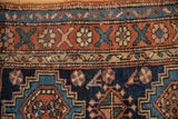 Close-up of the coarse knotting and wide floral border on a circa 1910s antique Heriz rug.