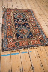 Angled perspective of an antique Heriz rug showing its traditional geometric motifs and time-softened texture.