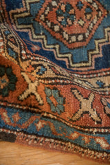 Coarse hand-knotted wool pile of an antique Persian Heriz rug in terracotta, teal, and sand.