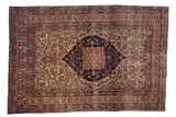 Antique Kermanshah rug with navy medallion, ivory floral field, and cochineal red borders.