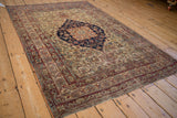 Close view of the antique Kermanshah rug's intricate cochineal red floral arabesque border.