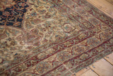 Worn antique Persian rug: floral blossoms, cochineal red border, visible foundation showing.