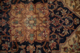 Antique Kermanshah rug close-up: worn floral blossoms in navy, cochineal red, and sand tones.