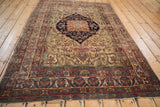 Kermanshah rug's expressive floral arabesque border in cochineal red, navy blue, with knot wear.