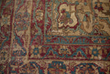 Kermanshah rug section, cochineal red and powder blue floral arabesques, with worn pile texture.