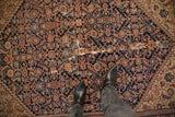 Antique Malayer rug detail: navy Herati pattern, terracotta, and areas of foundation showing.