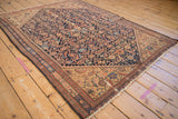 Antique Persian Malayer rug detail: Herati pattern in navy and terracotta, stepped spandrel, visible wear.