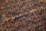 Antique Persian Malayer rug's intricate Herati pattern, displaying navy, terracotta, and visible wear.