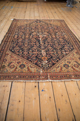 Beige fringe and banded border with stepped spandrel motif on an antique Malayer rug.