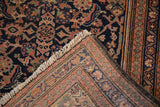 Folded corner of antique Malayer rug, displaying hand-knotted Herati pattern, fringe, and visible foundation.
