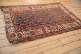 Tattered side of antique Malayer rug, showcasing ivory geometric border and alternating boteh patterns.