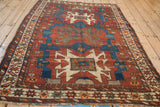 Vintage Caucasian rug's geometric angular borders in sapphire blue, black cherry red, and ivory.