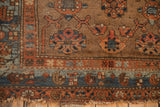 Corner detail of antique Kurdish Hamadan rug with floral trellis field, blue abrashes, and tattered fringe.