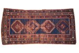 Antique Caucasian runner, navy blue field, repeating red geometric medallions, varied borders, aged patina.