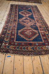End detail of antique Caucasian runner, circa 1920s, showing tattered fringe, geometric border, navy, and cherry red.