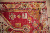 Distressed cherry red and saffron yellow geometric floral border of vintage Oushak rug.