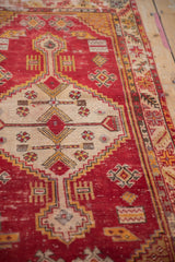 Distressed vintage Oushak rug: cherry red field with ivory stepped medallion and geometric florals.