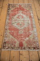 Distressed Turkish Oushak rug runner side with worn blush, beige, and charcoal palmette motifs.