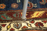 Eames chair's insulated dome glide on a blue and red Persian Hamadan rug.