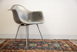 Elephant grey fiberglass Eames chair, showcasing its fibrous shell and unique side profile.