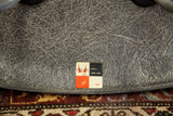 Eames elephant grey chair underside with visible fiberglass swirls, Zenith sticker, rope edge.