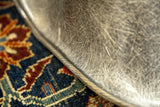 Eames LAX chair's rope edge and elephant grey fiberglass texture over a blue Persian rug.