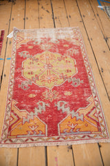 Distressed Oushak runner featuring cherry red field, lime green medallion, and worn texture.