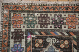 Distressed Oushak runner close-up: low pile, geometric patterns, tangerine, charcoal, ivory fringe.