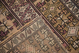 Worn beige and blush geometric patterns on distressed vintage Melas rug corner.