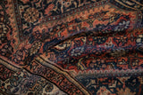 Textured pile of Malayer rug showcasing faded brick red, navy blue, and pale rose Herati design.