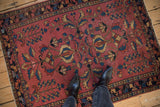 Primitive floral and germinating tree-of-life motifs on antique Lilihan rug; dusty raspberry, navy, beige.