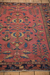 Antique Lilihan rug's primitive germinating tree of life pattern in worn raspberry and navy blue.