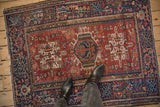 Black boots on a vintage Karaja rug, highlighting its triple medallion and red geometric field.