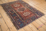 Navy blue border with rectilinear tree of life motif and tattered edge on a vintage Karaja rug.
