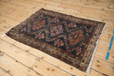 Antique Mehriban rug detail: sapphire blue medallion, germinating plants, and storied wear.
