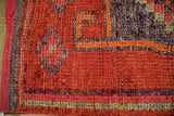 Distressed vintage Kurd rug detail: bright burnt orange, aubergine, and jade green geometric texture.