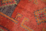 Distressed Kurd runner detail: vibrant burnt orange, aubergine, and jade geometric pile texture.