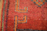 Distressed Kurd rug close-up, highlighting textured ruby red, burnt orange, and oxidized silver pattern.