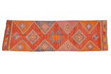 Distressed vintage Kurd rug runner with faded coral, orange, and grey geometric diamond and pinwheel motifs. 3'1