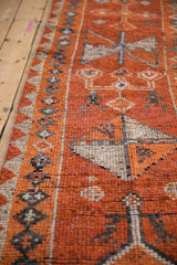 Textured pile of a distressed Kurd runner, showing burnt orange and time-softened ivory tones.
