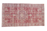 Distressed vintage Sparta rug with faded roundel medallion, blossoms, and deep raspberry, ivory, mauve.