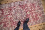 Distressed vintage Sparta rug showcasing faded raspberry and ivory patterns underfoot.
