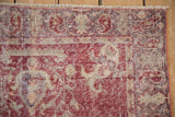 Distressed texture of this vintage Sparta rug showing visible knot heads and muted raspberry hues.