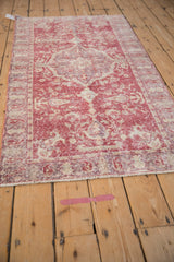 Distressed vintage Turkish Sparta rug in deep raspberry and ivory with faded floral patterns.