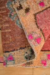 Folded vintage Kars rug, showing textured short pile, secured side, and fuchsia patterns.